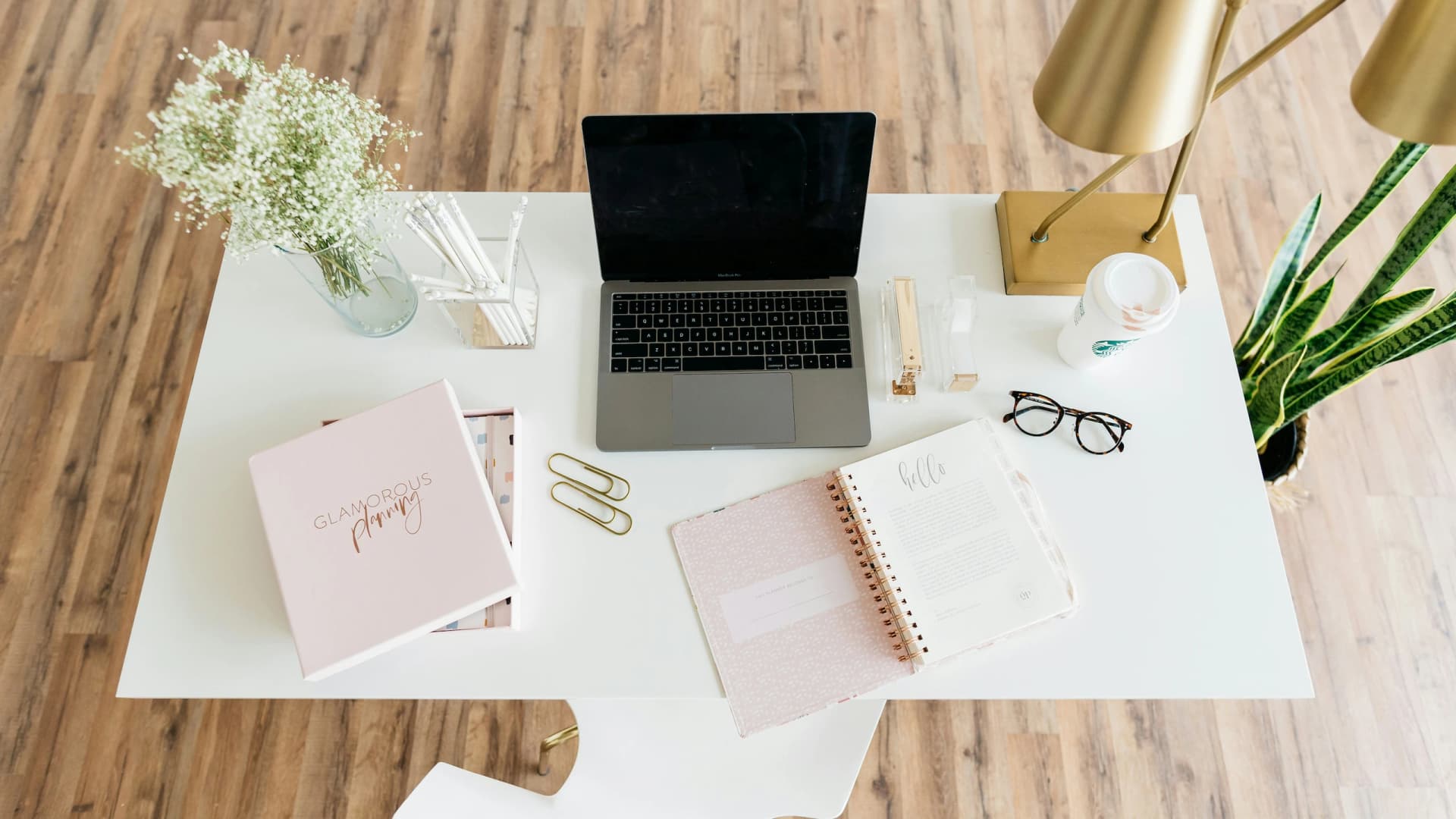 Bureau moderne vu du dessus avec ordinateur portable, carnet et accessoires de travail